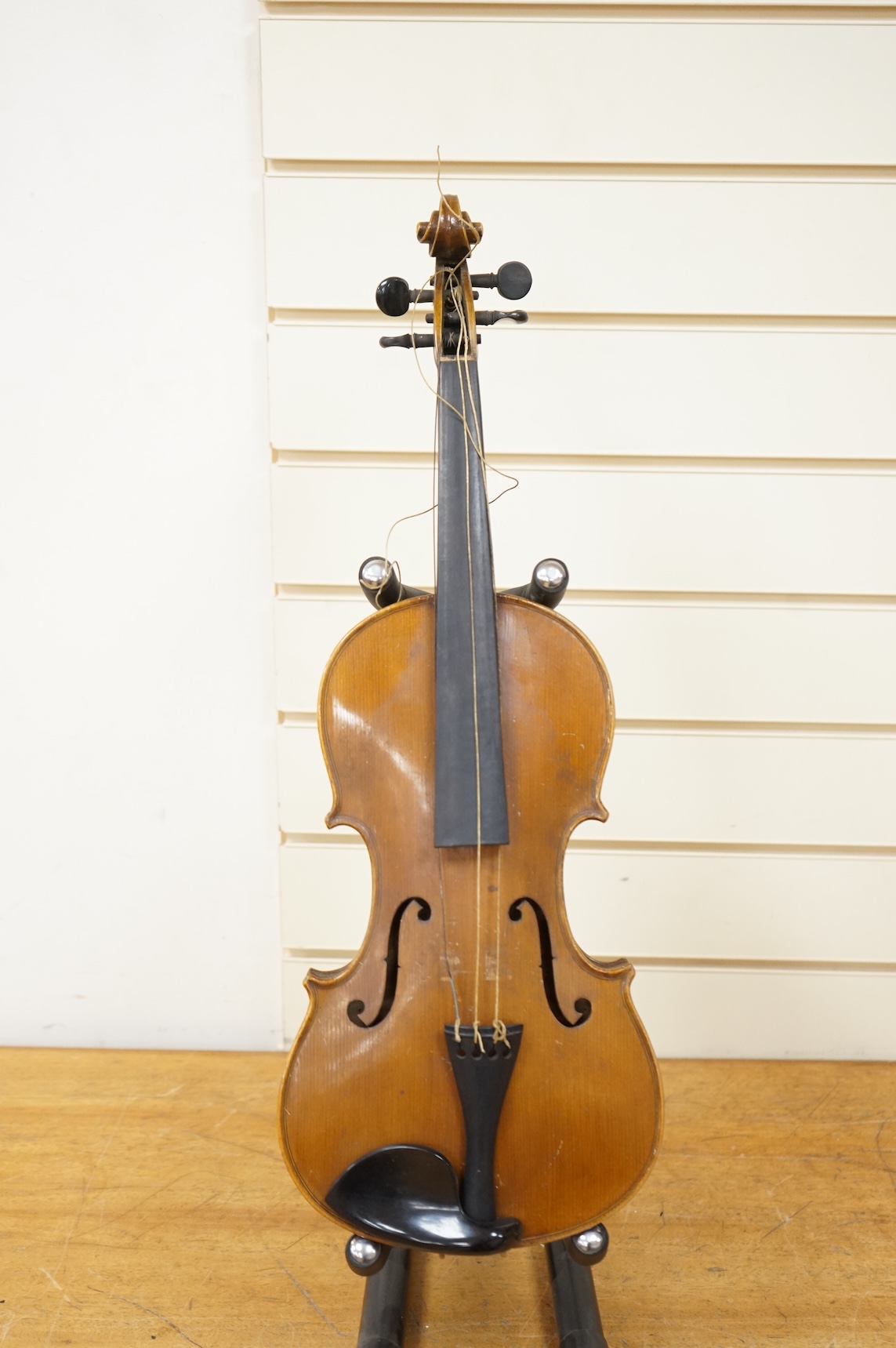 Three cased violins; a German Dresden violin, supplied by Campbell and co., Glasgow, together with another Dresden Stradivarius copy, and the remains of a European violin.